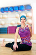 Young woman doing yoga on the floor of gym