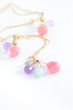 Gold chain and colored earrings on white background