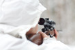 Soldier in white camouflage aiming with sniper rifle at winter f