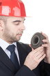 Young handsome engineer examine a gear Young handsome engineer examine a gear