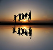 silhouette of friends jumping in sunset silhouette of friends jumping in sunset