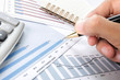 hand holding pen over Business background