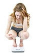 Young girl on bathroom scale looking upset