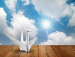 White fold paper bird on wood floor White fold paper bird on wood floor