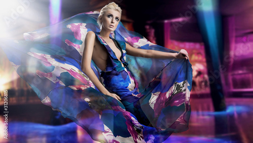 Photo: Beautiful woman in gorgeous dress over city background Beautiful woman in gorgeous dress over city background