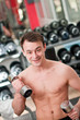Young man lifting bumbbell in sport club Young man lifting bumbbell in sport club