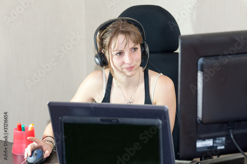 Photo: girl with headphone playing on computer or talking skype msn girl with headphone playing on computer or talking skype msn