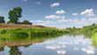 Countryside landscape with river,lone tree and clouds
