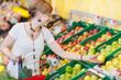junge frau kauft gesundes obst