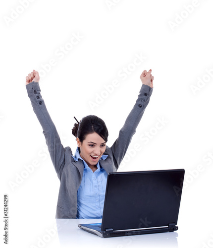 Foto: Young woman in office jubilates at desk Young woman in office jubilates at desk