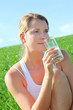 Beautiful blond woman drinking milk in countryside