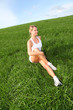 Beautiful woman doing fitness exercises in nature