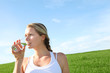 Photo: Woman drinking natural water in green field Woman drinking natural water in green field