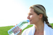 Woman drinking water from water during fitness activity