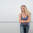 Beautiful blond woman standing on grey background