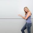 Beautiful blond woman standing on grey background