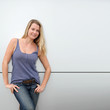 Beautiful blond woman standing on grey background