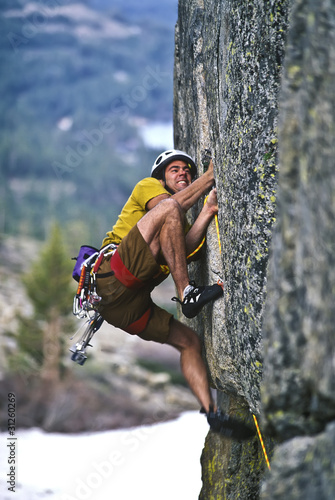 Photo: Rock climber clinging to a cliff. Rock climber clinging to a cliff.