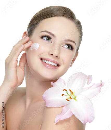 사진:Happy teen with flower applying cream Happy teen with flower applying cream