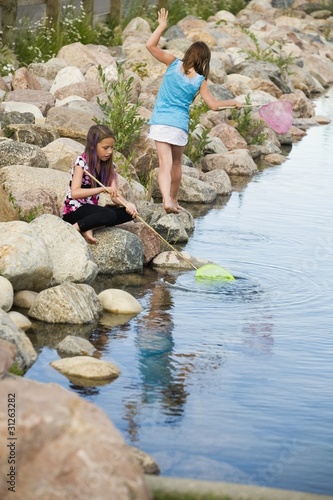 Photo: Two Girls Playing By The Water Two Girls Playing By The Water