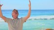 Elderly man on a beach expressing joy