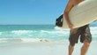 Man with surf board  getting out of the water 