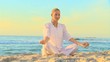 Video: Woman in white doing yoga on the beach Woman in white doing yoga on the beach