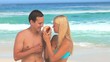 Beautiful young couple listening  to a shell