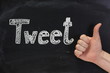 Thumbs up sign for the word Tweet on a Blackboard