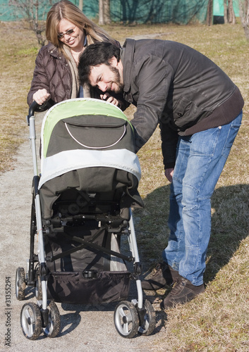 Photo: Happy Family Walking with Stroller Happy Family Walking with Stroller