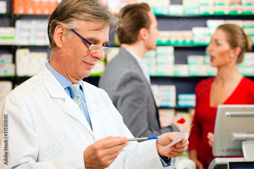 Photo: Pharmacist with customers in pharmacy Pharmacist with customers in pharmacy
