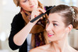 Stylist pinning up a bride’s hairstyle