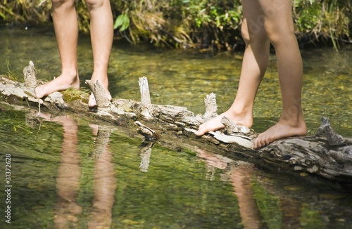 Photo: Children Standing On A Log In A Stream Children Standing On A Log In A Stream