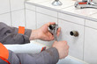 Plumber hands fixing water pipe with spanner Plumber hands fixing water pipe with spanner
