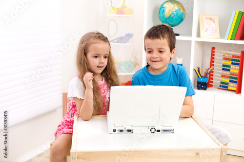 Photo: Two kids looking at laptop computer Two kids looking at laptop computer