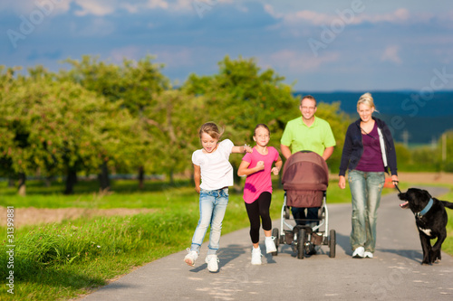 Photo: Familie mit Kindern und Hund auf Spaziergang Familie mit Kindern und Hund auf Spaziergang