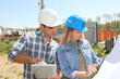 Engineers on construction site with plan