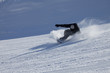 Snowboarder on the downhill in sunny day