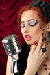 beautiful redhead woman singing into vintage microphone