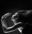 Foto: Beauty portrait of woman with flying hair over black Beauty portrait of woman with flying hair over black