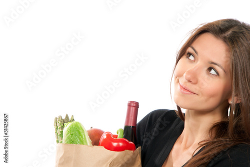 Photo: Close-up woman hold shopping paper bag full of vegetarian grocer Close-up woman hold shopping paper bag full of vegetarian grocer