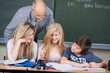 drei schüler mit lehrer im unterricht
