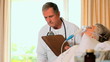 Doctor attending to woman in hospital bed