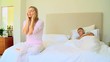 Young woman on bed seeking serenity while hubsand sleeps