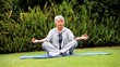 Mature  woman doing yoga outdoors on a mat 