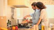 Young woman watching her boyfriend do the cooking