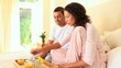 Young couple having breakfast in bed