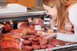 kundin in der metzgerei wählt salami aus kundin in der metzgerei wählt salami aus