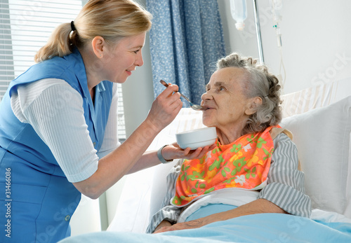Photo: senior woman 90 years old being fed by a nurse senior woman 90 years old being fed by a nurse