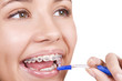 happy girl with braces brushing her teeth